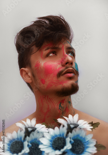 Man with face paint holding bouquet of flower photo