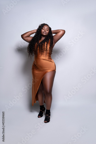 Portrait of plus size model in orange dress standing photo