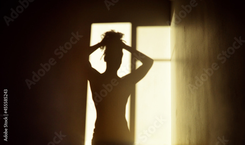 Shadow of woman figure in front of window photo