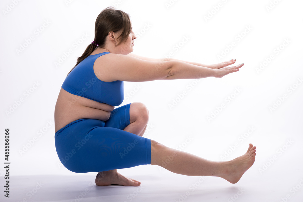 a girl of European appearance in a blue suit is engaged in fitness or yoga. White background. not a perfect figure. Sports training. Coordination exercise a girl of European appearance in a blue suit is engaged in fitness or yoga. White background. not a perfect figure. Sports training. Coordination exercise