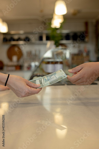 Two hand exchanging twenty Jordanian Dinars photo