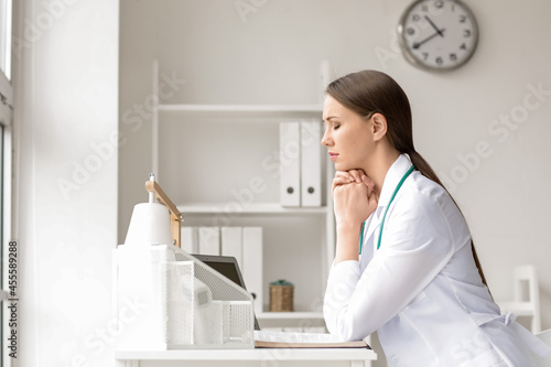 Praying female doctor in cl...