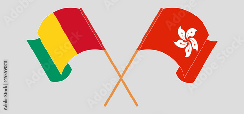 Crossed and waving flags of Guinea and Hong Kong