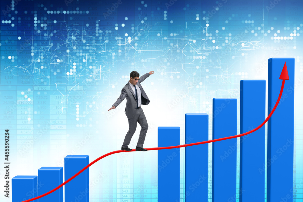 Businessman walking on tight rope between bar chart Businessman walking on tight rope between bar chart