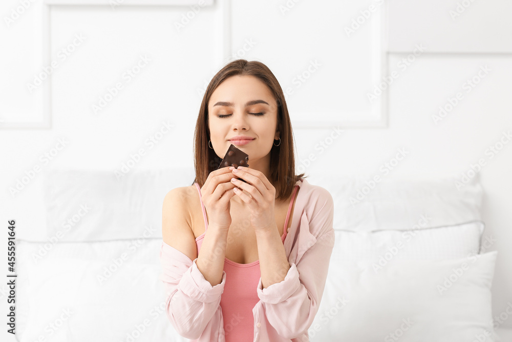 Beautiful young woman with tasty chocolate at home Beautiful young woman with tasty chocolate at home