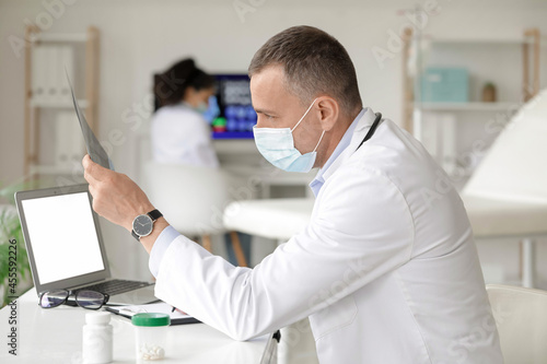 Mature doctor studying x-ray scan in clinic