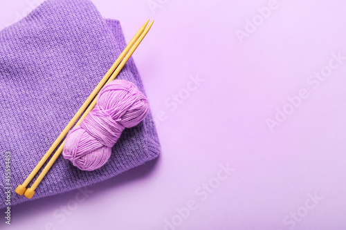 Фотография Yarn with knitting needles and plaid on color background