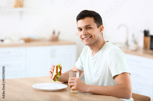 Young man with tasty sandwi...