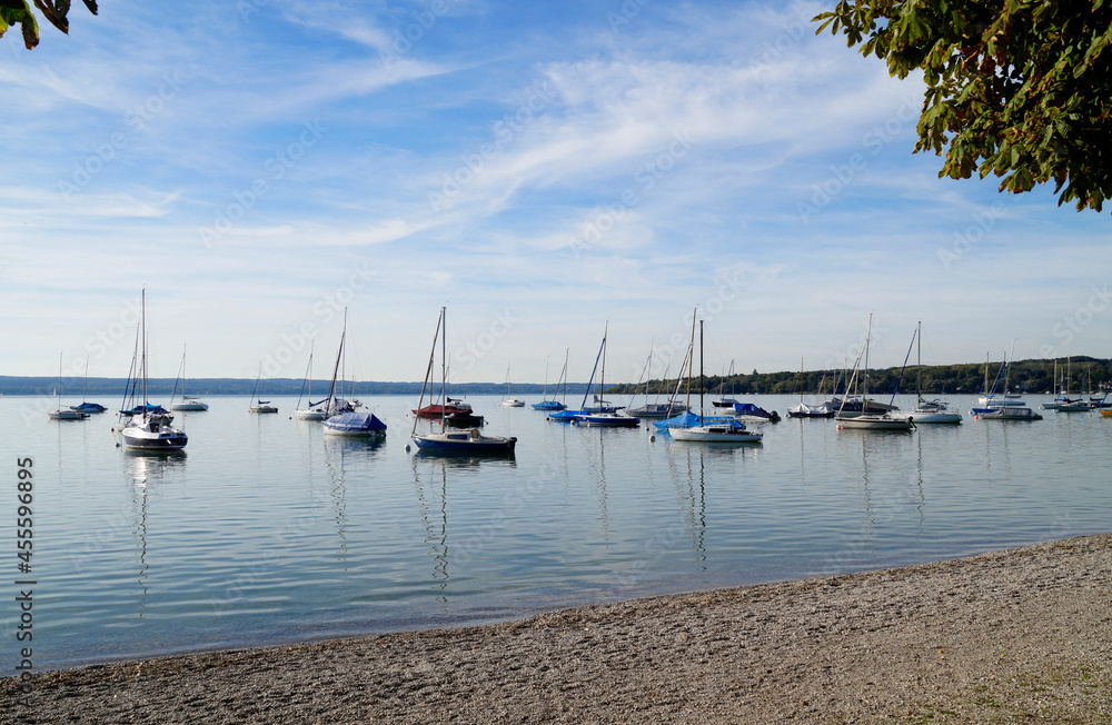a scenic view of sailing boats in the sun on lake Ammersee in Germany (Herrsching in Germany) a scenic view of sailing boats in the sun on lake Ammersee in Germany (Herrsching in Germany)