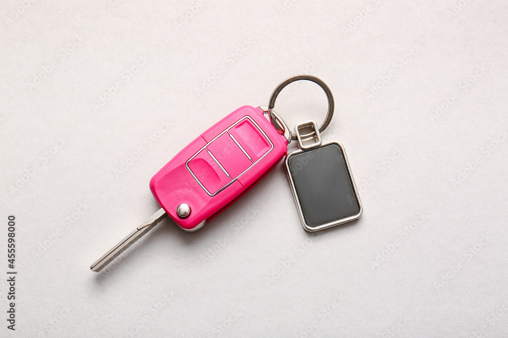 Car key with stylish keychain on light background Car key with stylish keychain on light background