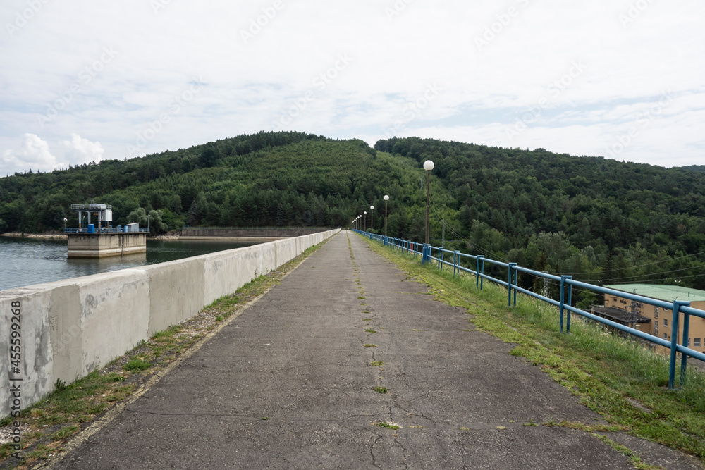 Walkway along the dam of Domaša Slovakia. To the right is a small hydroelectric power plant and to the left is a technological device to regulate the flow of water