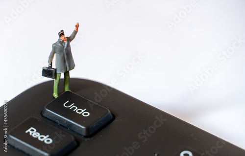 Картината върху платно Miniature man with With Left Arm in the Air next to Undo Key