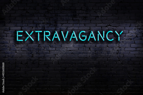 Neon sign. Word extravagancy against brick wall. Night view photo
