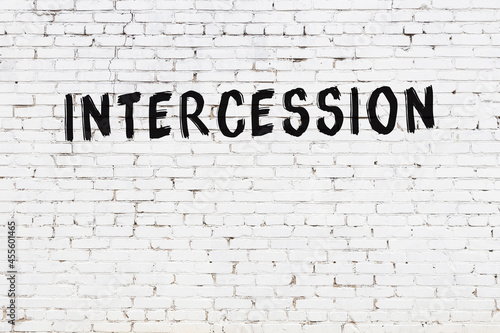 Photography White wall with black paint inscription intercession on it