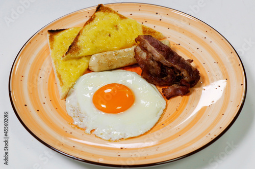 healthy break fast concept, fried egg sunny side up, cheese toast, crispy bacon and sausage photo