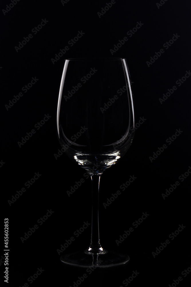 wine glasses and bottles with liquids marking their silhouette with light and black background