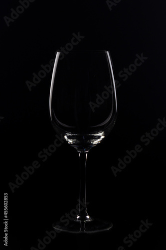 wine glasses and bottles with liquids marking their silhouette with light and black background