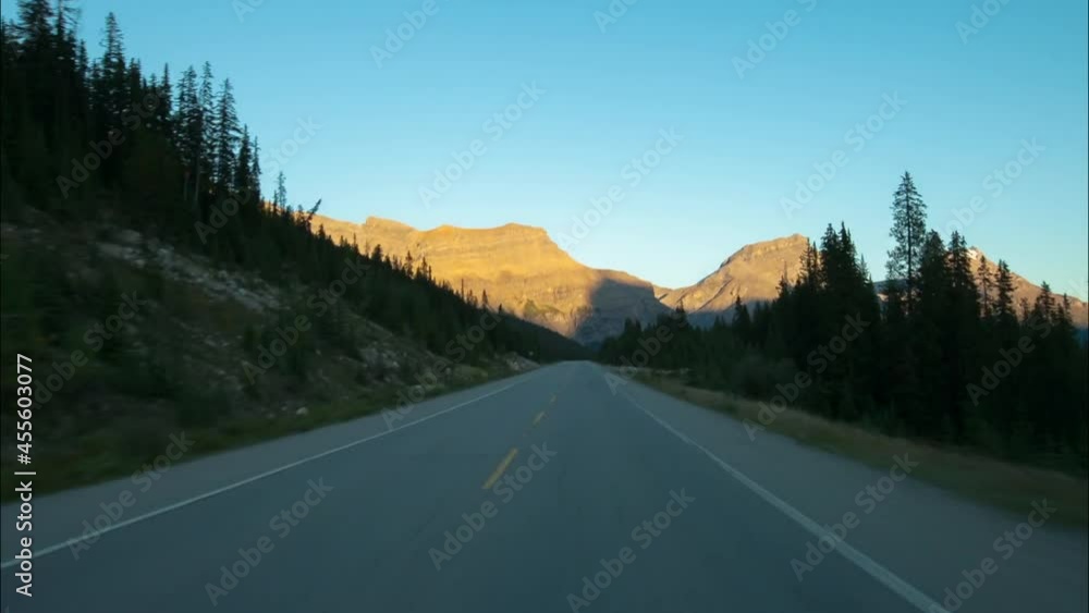 Time Lapse Scenic Shot Of Car Moving On Road Amidst Trees By Rock Formations - British Columbia, Canada