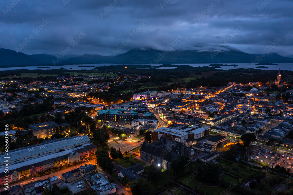 Fototapeta premium Aerial view of scenic tourist town of Killarney in county Kerry in Ireland with switched on lights under a cloudy early rise morning cloudy sky