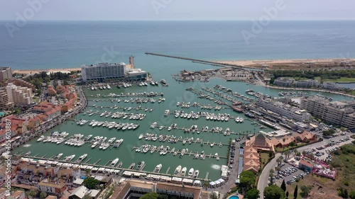 Aerial video of the tourist Portuguese town of Vilamoura, with views of the beaches and docks for luxury yachts, hotels and restaurants. Portugal, Algarve.