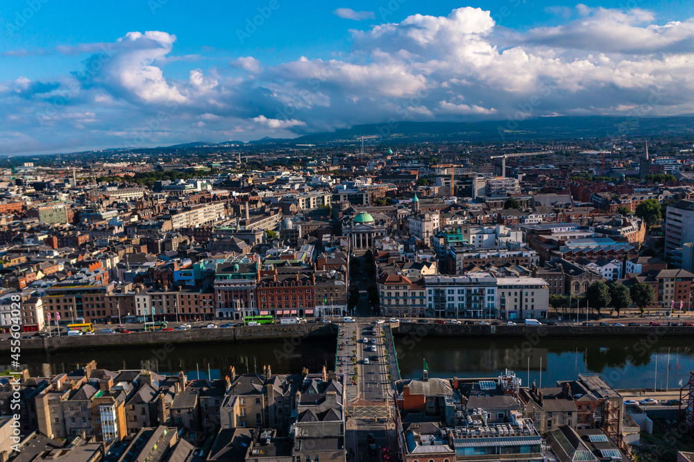 Aerial view of skyline of Dublin with river flowing with cars running on bridge connecting two sides of street surrounded by buildings during a cloudy day
