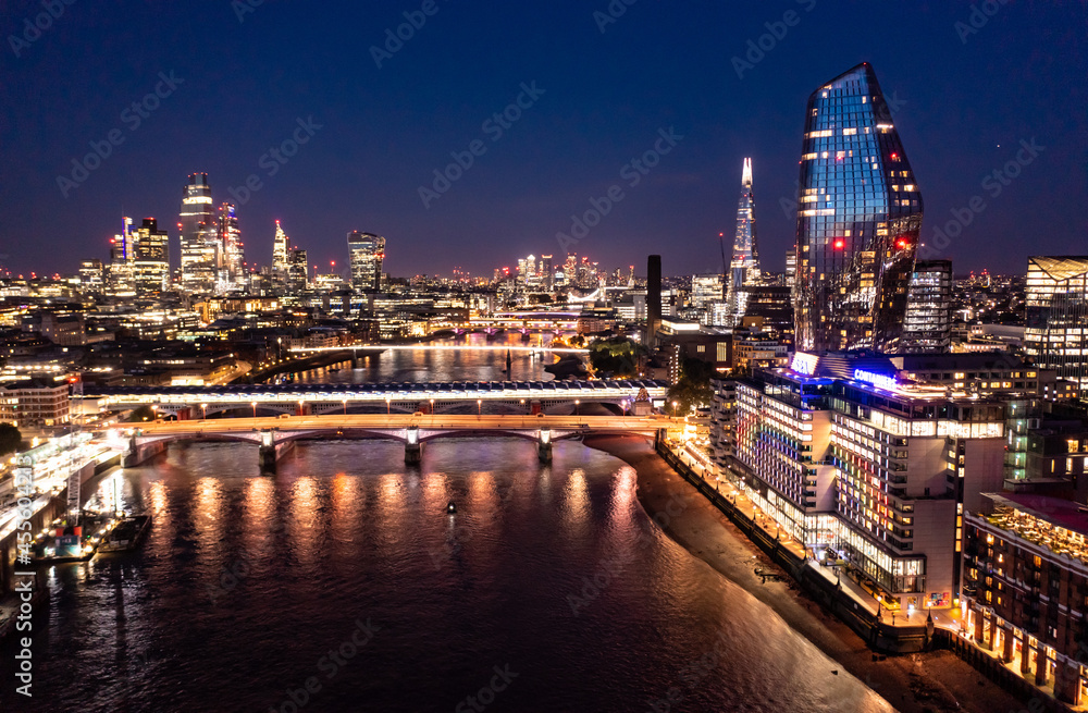 Night view of the beautiful London city with urban architectures bridge at distance with skyscrapers and small buildings around ocean water