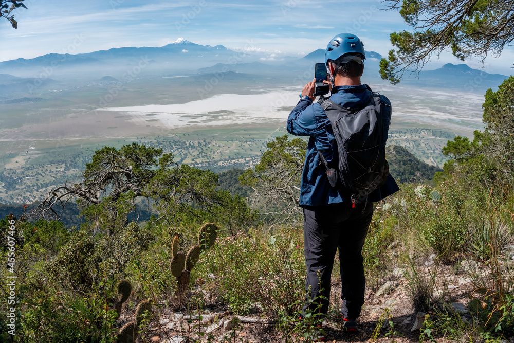 Young man standing on top mountains enjoying view of nature