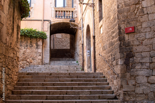 Fototapeta Naklejka Na Ścianę i Meble -  Empty alley with stone stairs in the old town, Girona