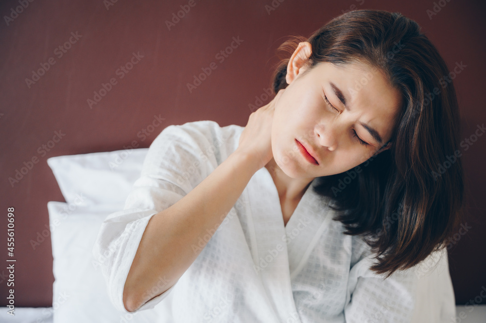 Portrait of young Asian woman having neck pain from strain, injury or office syndrome. Neck pain caused from poor posture from work or overuse. Portrait of young Asian woman having neck pain from strain, injury or office syndrome. Neck pain caused from poor posture from work or overuse.