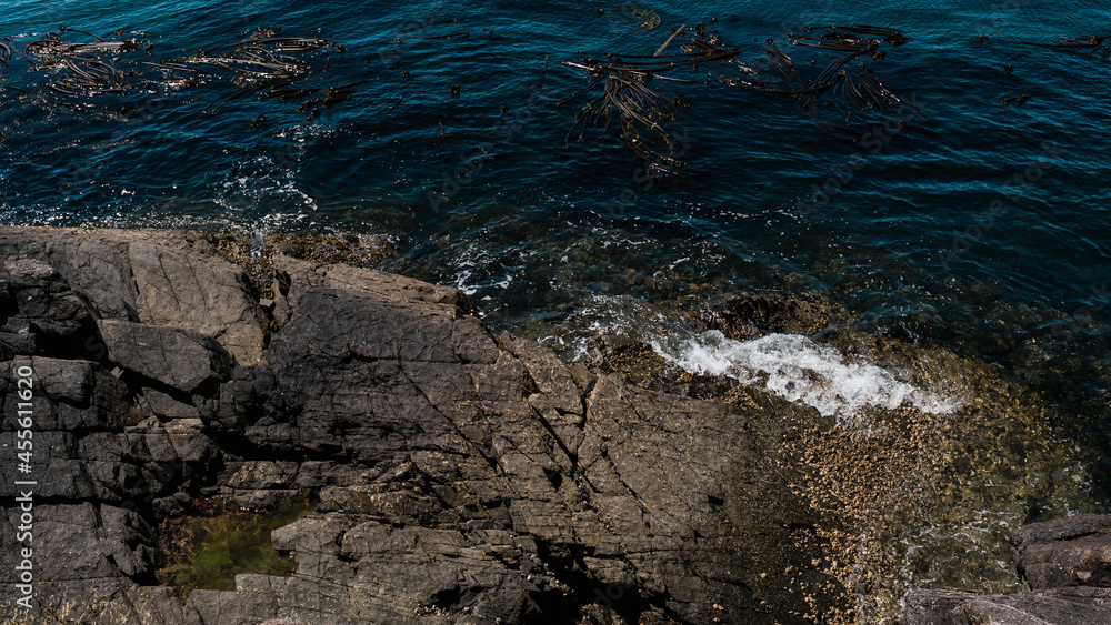 Waves crashing on a rocky shore in the ocean. Waves crashing on a rocky shore in the ocean.