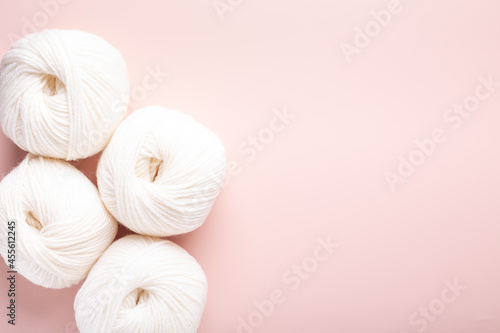 White clews of wool on a pink background. Place for your text. Top view