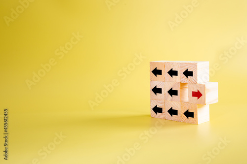 Wooden block with red arrow facing the opposite direction black arrows