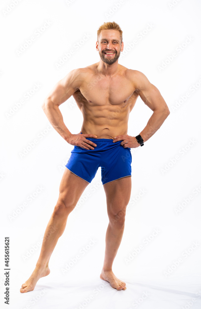 full-length portrait of a jock. man in blue shorts posing on a white background.