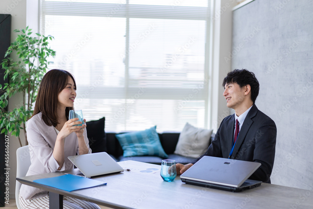 オフィスで楽しく話す男女 オフィスで楽しく話す男女