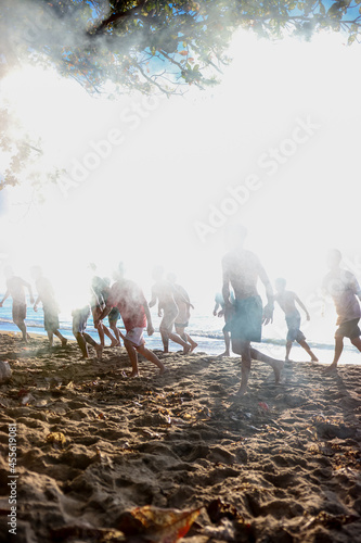 portrait photo of many people dancing on the beach, full of thick smoke