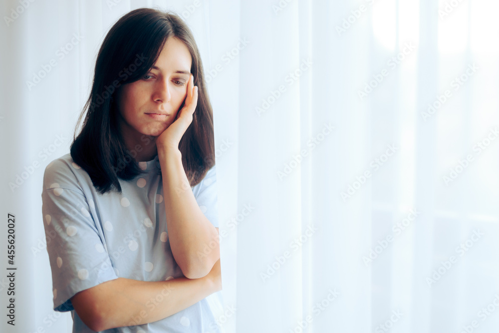 Depressed Woman Feeling Sad Standing by the Window Depressed Woman Feeling Sad Standing by the Window