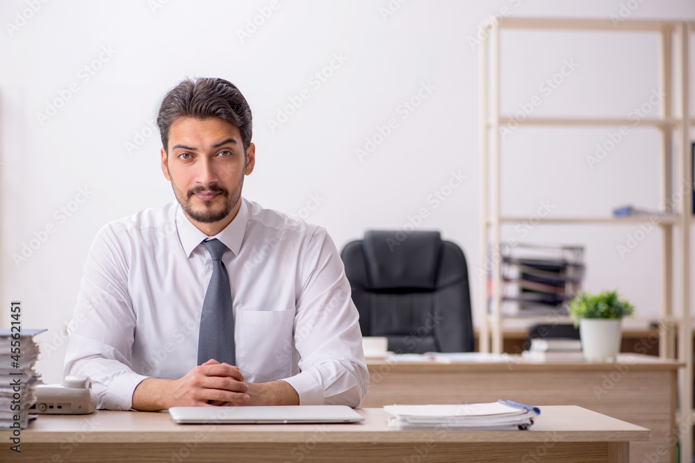 Young male employee and too much work in the office Young male employee and too much work in the office