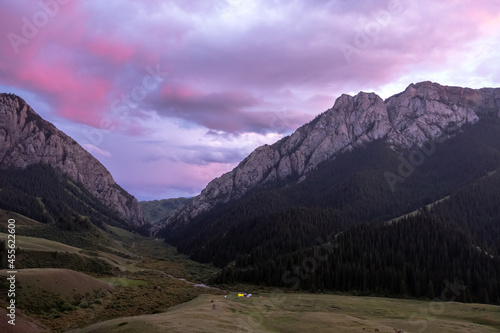 Beautiful pink sunset in rocky mountains with pink clouds on background. Nature landscape background. Wilderness background. Komirshi gorge in Kazakhstan. Travel journey concept. photo