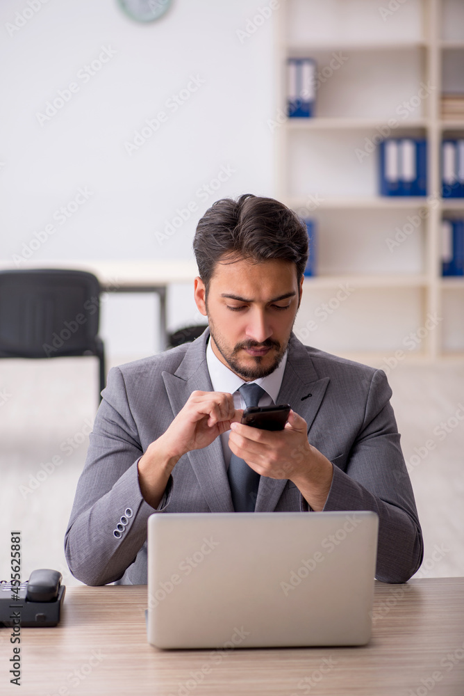 Young male employee and too much work in the office Young male employee and too much work in the office