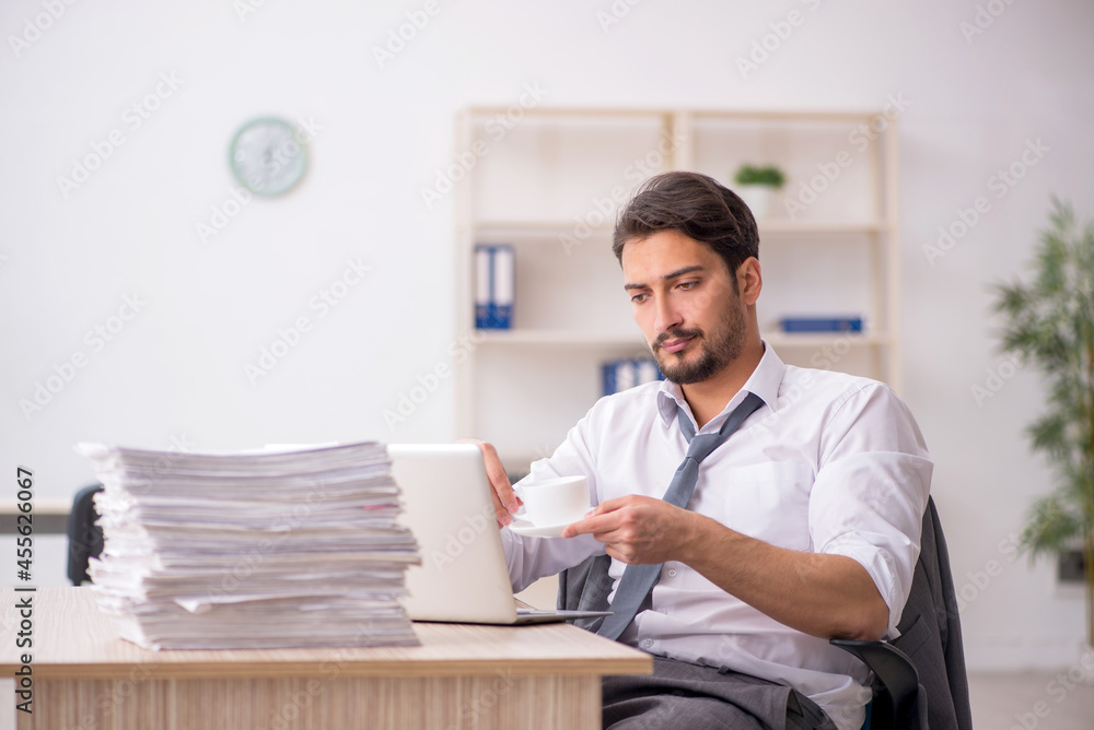 Fototapeta premium Young male employee drinking coffee during break