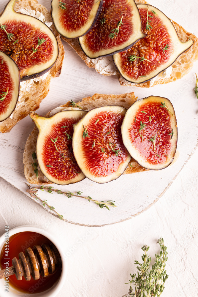 Breakfast with sweet bruschettas with figs and honey on a white plate Breakfast with sweet bruschettas with figs and honey on a white plate