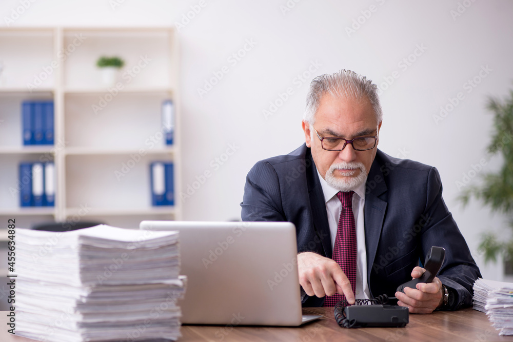 Old male employee and too much work in the office Old male employee and too much work in the office