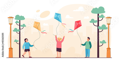 Cartoon kids holding flying kites in city park. Flat vector illustration. Little girls and boy having fun, playing, enjoying the wind and fresh air. Game, childhood, walk, hobby concept for design