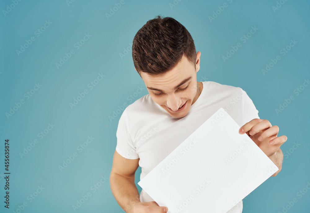 Cheerful man with a sheet of paper in his hands Copy Space emotions blue background Cheerful man with a sheet of paper in his hands Copy Space emotions blue background
