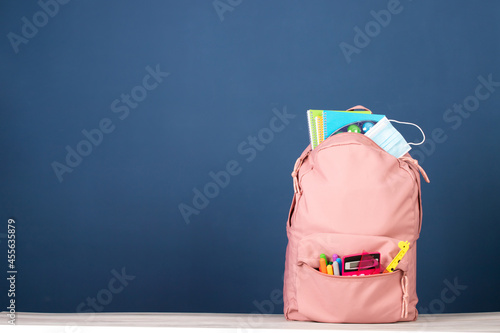  Backpack with different school stationery and medical mask. Coronavirus concept. photo