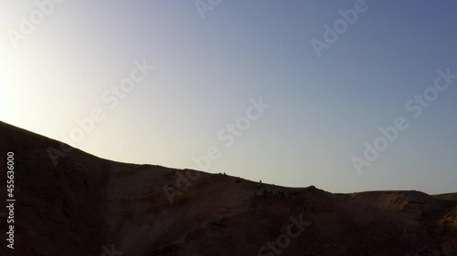 Aerial: People On Top Of Desert Cliff Against Clear Sky - Shaharut, Israel photo