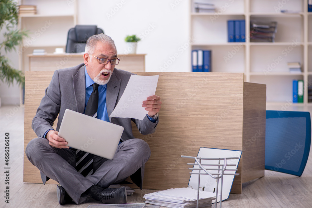 Old male employee unhappy with excessive work in the office Old male employee unhappy with excessive work in the office