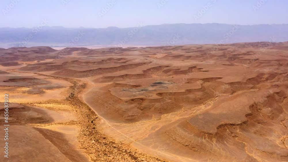 Aerial Panning Shot Of Brown Dramatic Landscape Against Sky During Sunny Day - Shaharut, Israel Aerial Panning Shot Of Brown Dramatic Landscape Against Sky During Sunny Day - Shaharut, Israel