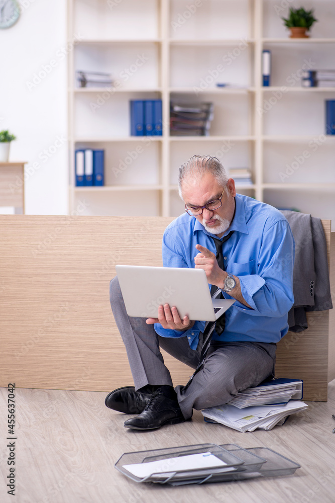 Old male employee unhappy with excessive work in the office Old male employee unhappy with excessive work in the office