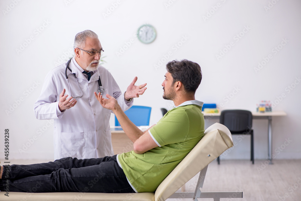 Obraz premium Young man visiting old male doctor